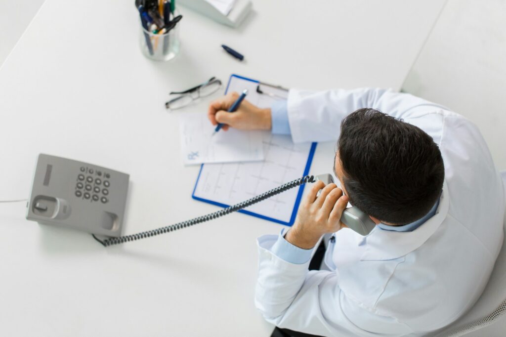 doctor with prescription calling on phone