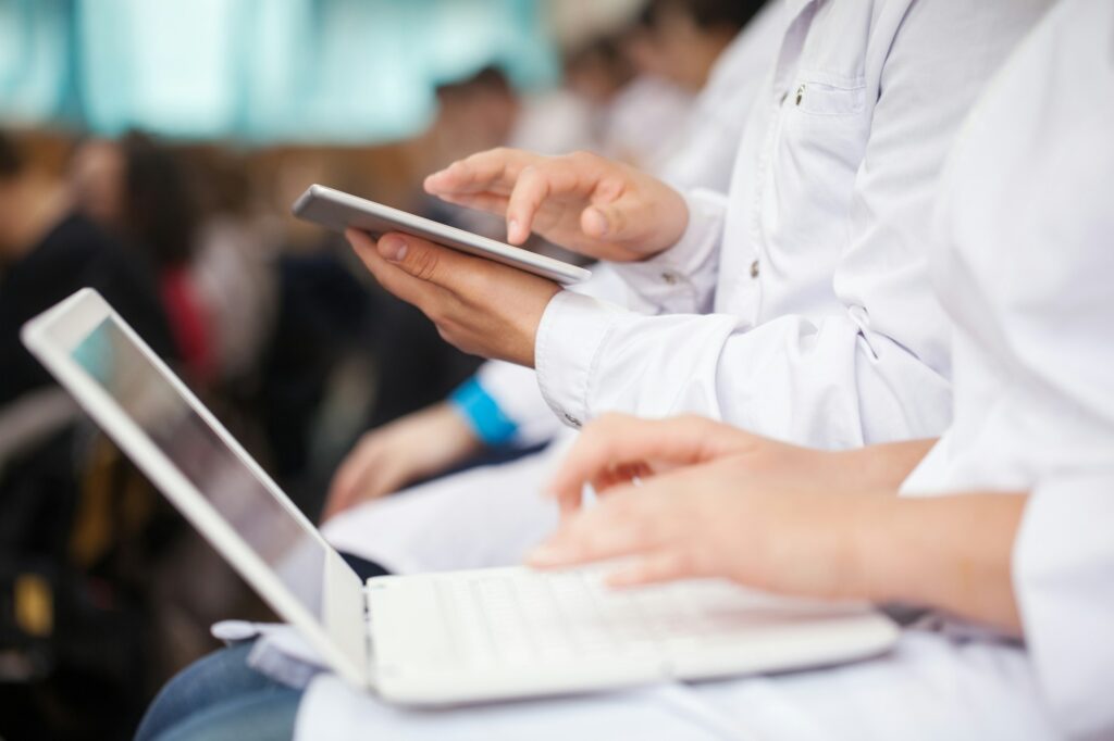 Medical students with pad and laptops in auditorium